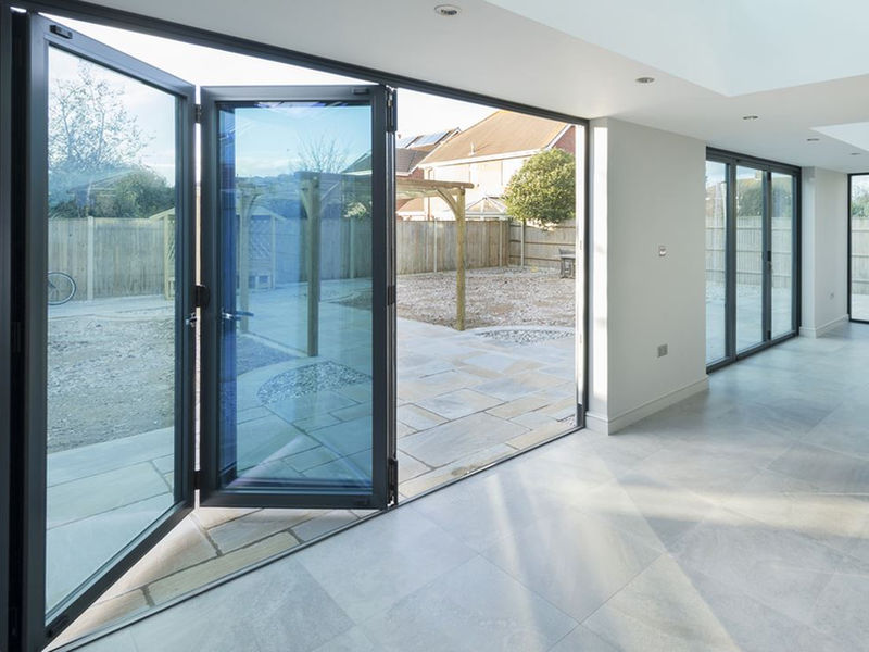 Grey WarmCore bi-fold doors opening onto a garden